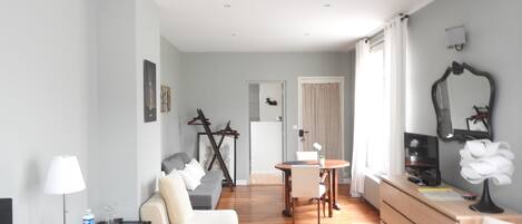Una sala de estar moderna con un sofá, una mesa de comedor y un televisor.