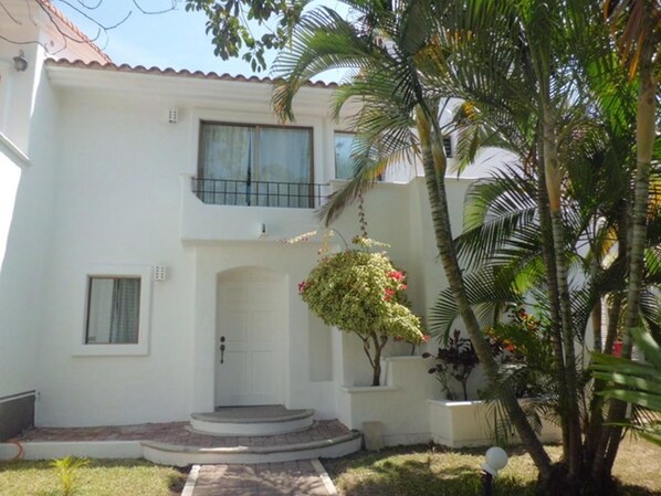 A two-story house with a white exterior, a front door, and a small balcony. - Casa - Condo (Mazatlán)
