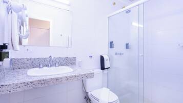 Moderni kylpyhuone, jossa on graniittinen allastaso, lasinen suihkuseinä ja wc-istuin.