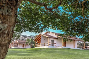 A two-story building with a covered porch and a grassy lawn.