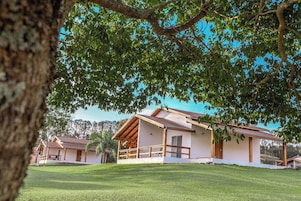 A two-story building with a covered porch and a grassy lawn.