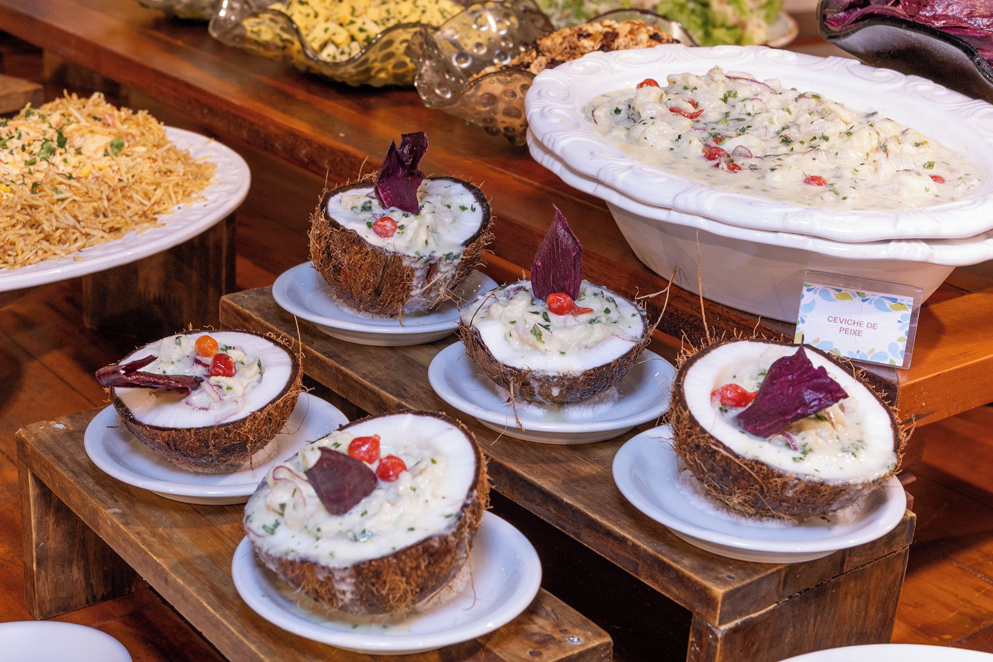 A variety of seafood dishes, including ceviche and seafood salad, displayed on a wooden table.