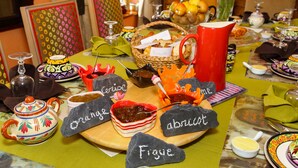 Une table dressée avec divers aliments et des étiquettes indiquant différents types de fromage.