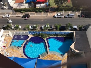 A rooftop swimming pool with multiple sections and a surrounding deck.
