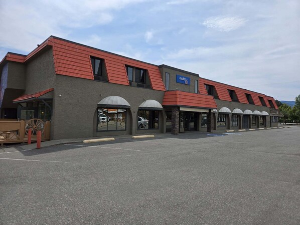 A motel with a red roof and multiple rooms. - Motel 6 Merritt BC (Merritt)