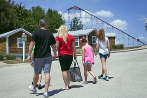 A group of people walking on a paved path. - Worlds of Fun Village (Kansas City)