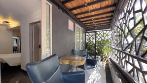 A modern outdoor seating area with blue chairs and a wooden table, a wooden ceiling, and a view through a lattice structure. - Provenza Lofts (Medellín)