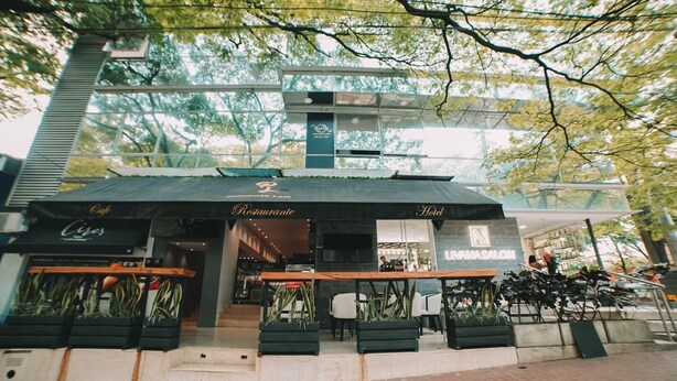 A building with a cafe, restaurant, and hotel signage. - Provenza Lofts (Medellín)