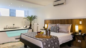 A modern hotel room with a bed, bedside table, nightstand, and a small balcony area. - Provenza Lofts (Medellín)