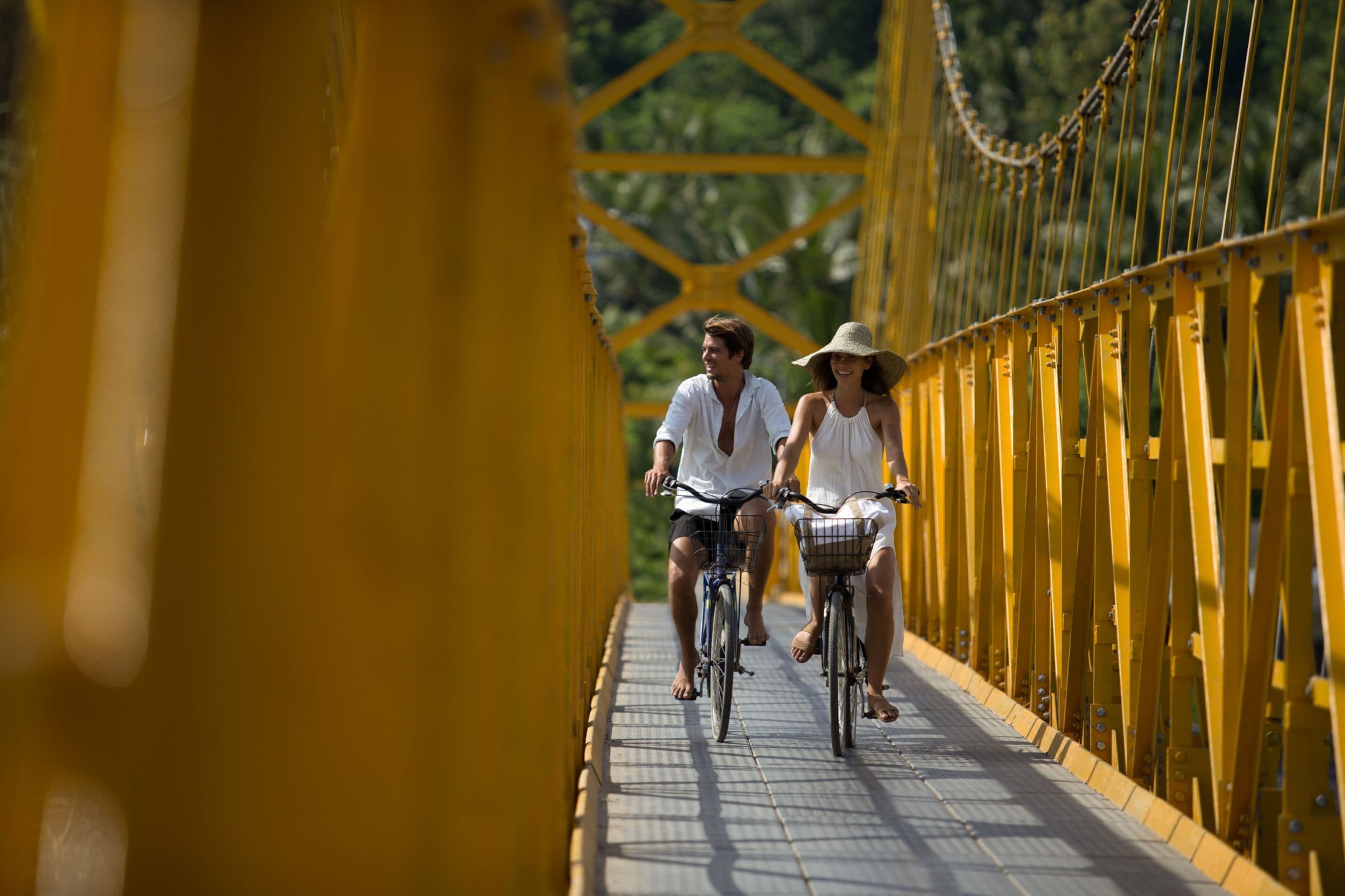 A yellow suspension bridge with metal railings and a metal walkway.
