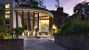 A modern building with a curved entrance, large windows, and a statue in the foreground. - The Tamarind Resort Nusa Lembongan Bali (Lembongan Island)
