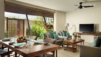 A modern living room with a dining area, a sofa set, a TV, and a ceiling fan.