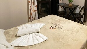 Habitación de hotel con cama, una mesa, una silla, equipo de aire acondicionado y televisor en la pared.