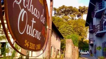 Letrero que indica 'Pousada Folhas de Outono' con un número de contacto.