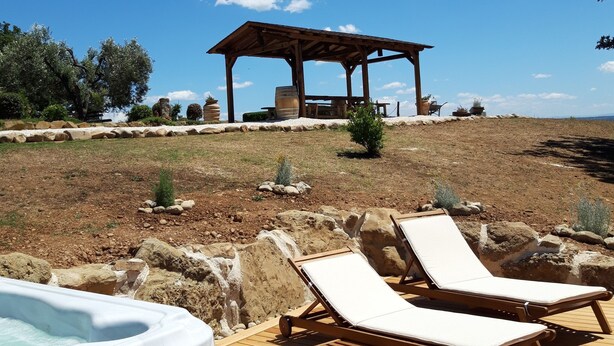 Eine Holzterrasse mit Liegestühlen und einem Whirlpool.