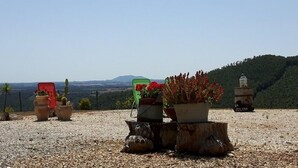Ein Kiesbereich mit Blumentöpfen und einem rustikalen Laternen, mit Blick auf eine Berglandschaft.