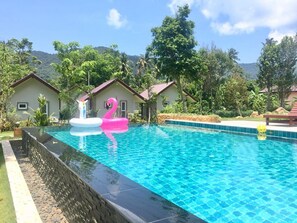 Una piscina al aire libre, sillones reclinables de piscina