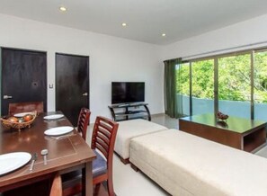 Departamento familiar, 2 camas matrimoniales, vista a la ciudad | Área de sala de estar | Televisión de pantalla plana 