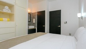 A modern hotel room with a large bed, a wardrobe, a small bathroom with a sink, and a shower area. - Davinci By Vtpvacaciones (Playa del Carmen)
