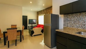 A modern kitchen with dark cabinets, a stainless steel refrigerator, and a tiled backsplash. - Davinci By Vtpvacaciones (Playa del Carmen)