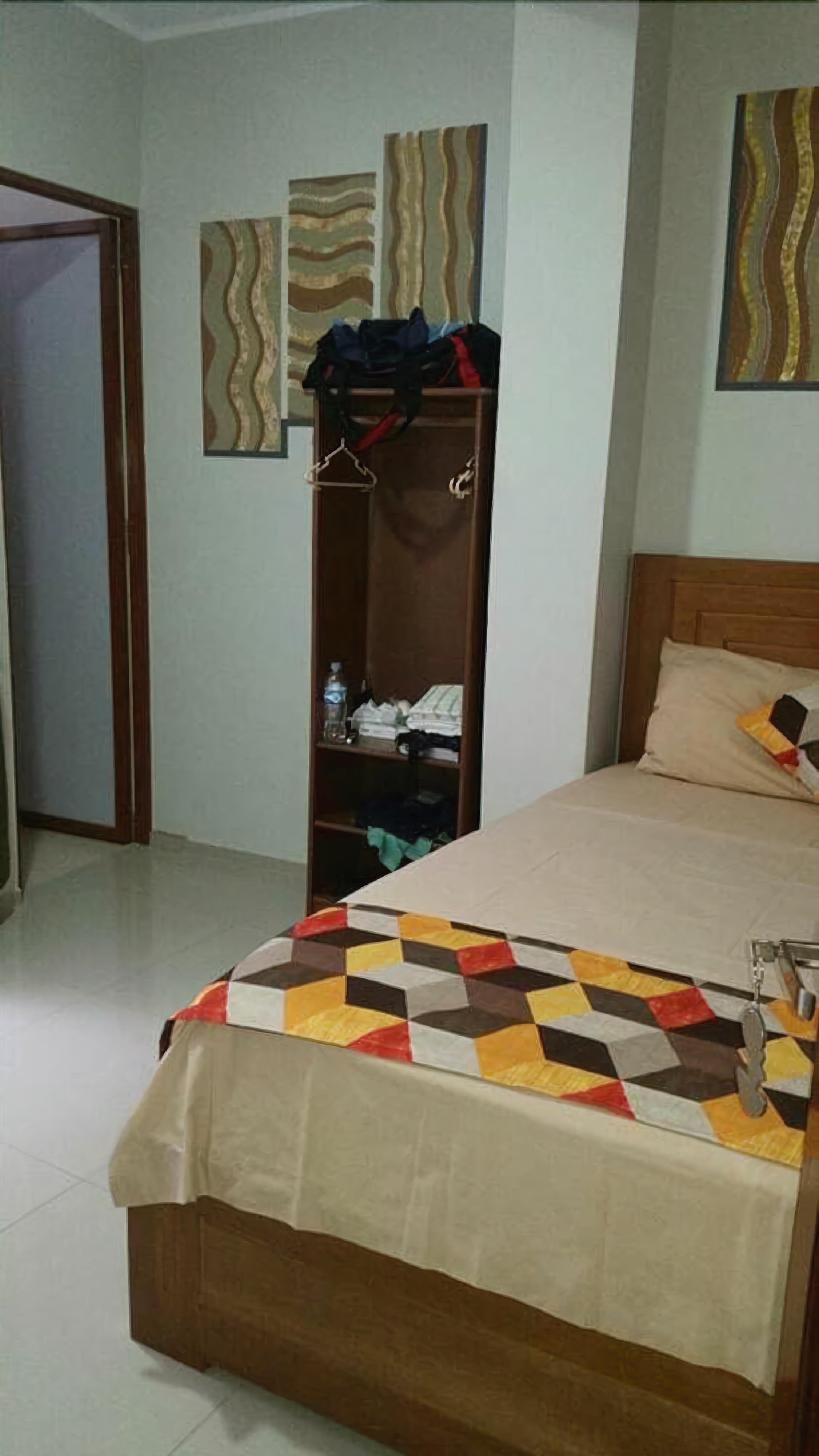 Un dormitorio con cama, un armario de madera y una puerta.