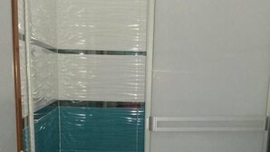 A small bathroom with a toilet, a shower enclosure, and a tiled floor. - Hospedaje Piolin (Tarapoto)