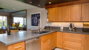 A modern kitchen with wooden cabinets, a stainless steel sink, and a built-in dishwasher.