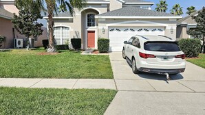 Une maison d’habitation avec une voiture blanche garée dans l’allée.
