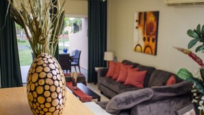 Una sala de estar con un sofá, una mesa de centro y un jarrón decorativo con una planta.