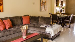 Una sala de estar con sofá, mesa de centro y mesa de comedor.