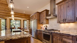 A modern kitchen with wooden cabinets, stainless steel appliances, and a large island.