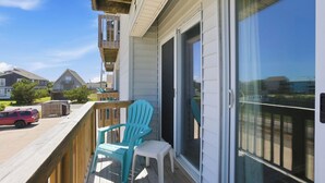 Ein Balkon mit einer Schiebeglastür, einem kleinen Tisch und zwei Stühlen.