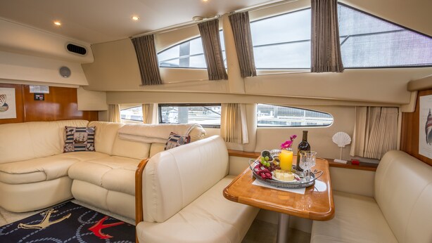 A cozy interior with a sofa and a table set with food and drinks. - Boston Harbor Yacht,  AC/Heat, Walk to North End WiFi (Boston)