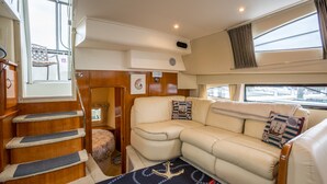 A cozy interior with a sofa, a rug with nautical designs, and a staircase. - Boston Harbor Yacht,  AC/Heat, Walk to North End WiFi (Boston)