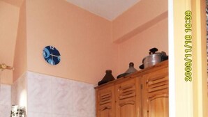 A kitchen with wooden cabinets, a stove, and a clock on the wall. - Apartment/ flat - ESSAOUIRA (Essaouira)