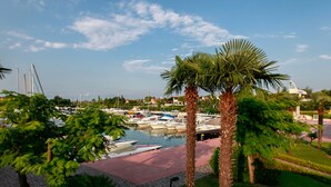 A marina with boats docked, surrounded by palm trees and greenery.