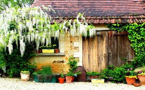 A rustic building with a weathered wooden door, a stone wall, and a tiled roof.