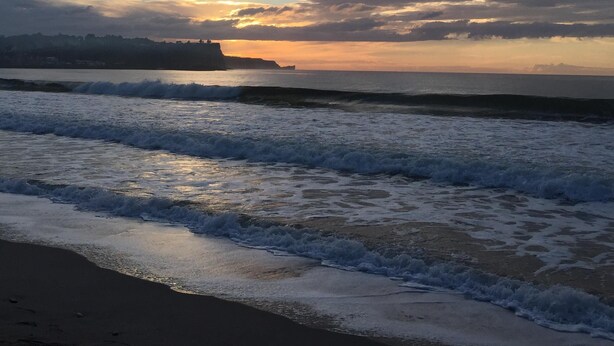A beach with waves and a sunset. - Stunning modern home in a perfect location (Ballycastle)