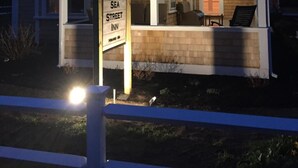 A two-story building with a covered porch and a sign for Sea Street Inn. - Sea Street Inn (Hyannis)