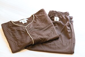 A pair of folded brown pants with a label on the waistband. - Tabino Hotel Sado (Sado)