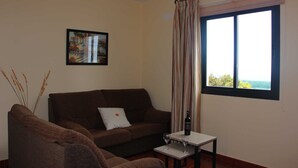 A living room with a sofa, a small table, and a window with a view. - Casa Luque, La Punta, Spain (Tijarafe)