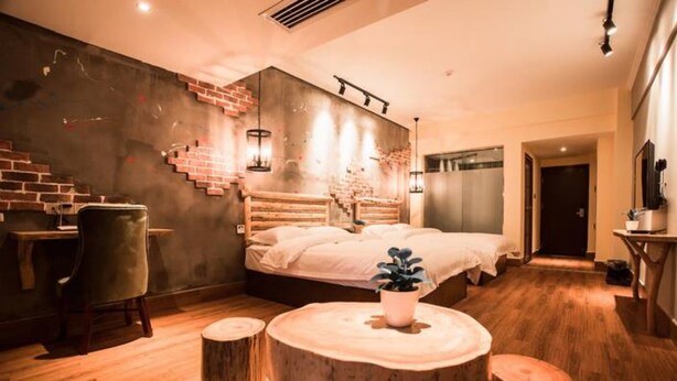 Een moderne slaapkamer met een groot bed, een bureau en een stoel. Een trap leidt naar een ander niveau.