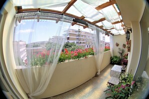 A balcony with a view of buildings and flowers.