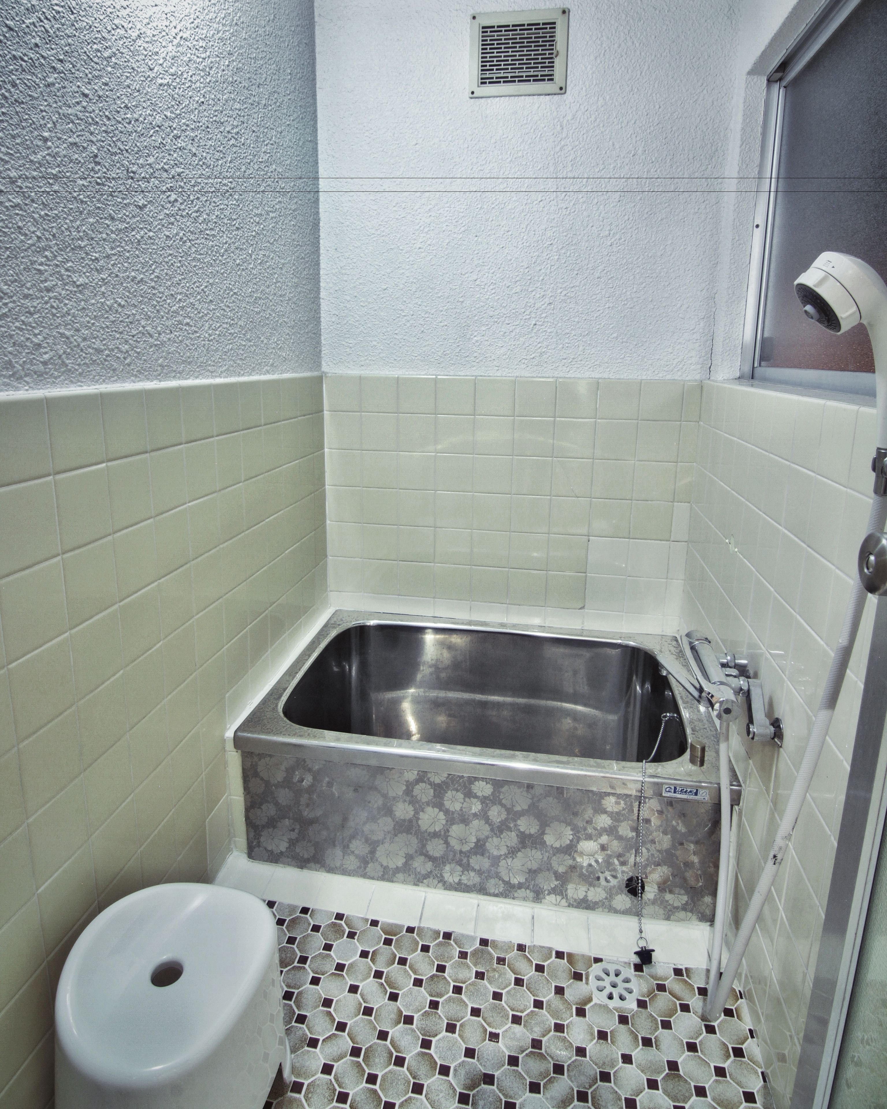 A bathroom with a bathtub, a toilet, and a shower.