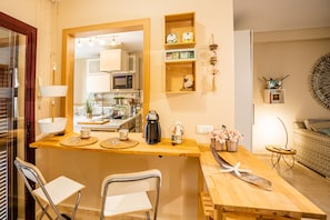 A compact kitchen with a central island, a microwave, and various kitchen utensils.