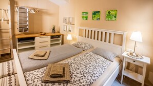 Ein Schlafzimmer mit einem Bett, Nachttischen, einem Kleiderschrank und einem Schreibtisch.
