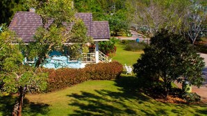 A residential area with houses, a well-maintained lawn, and a clear blue sky. - Cottages at Hill Resort (Pak Chong)