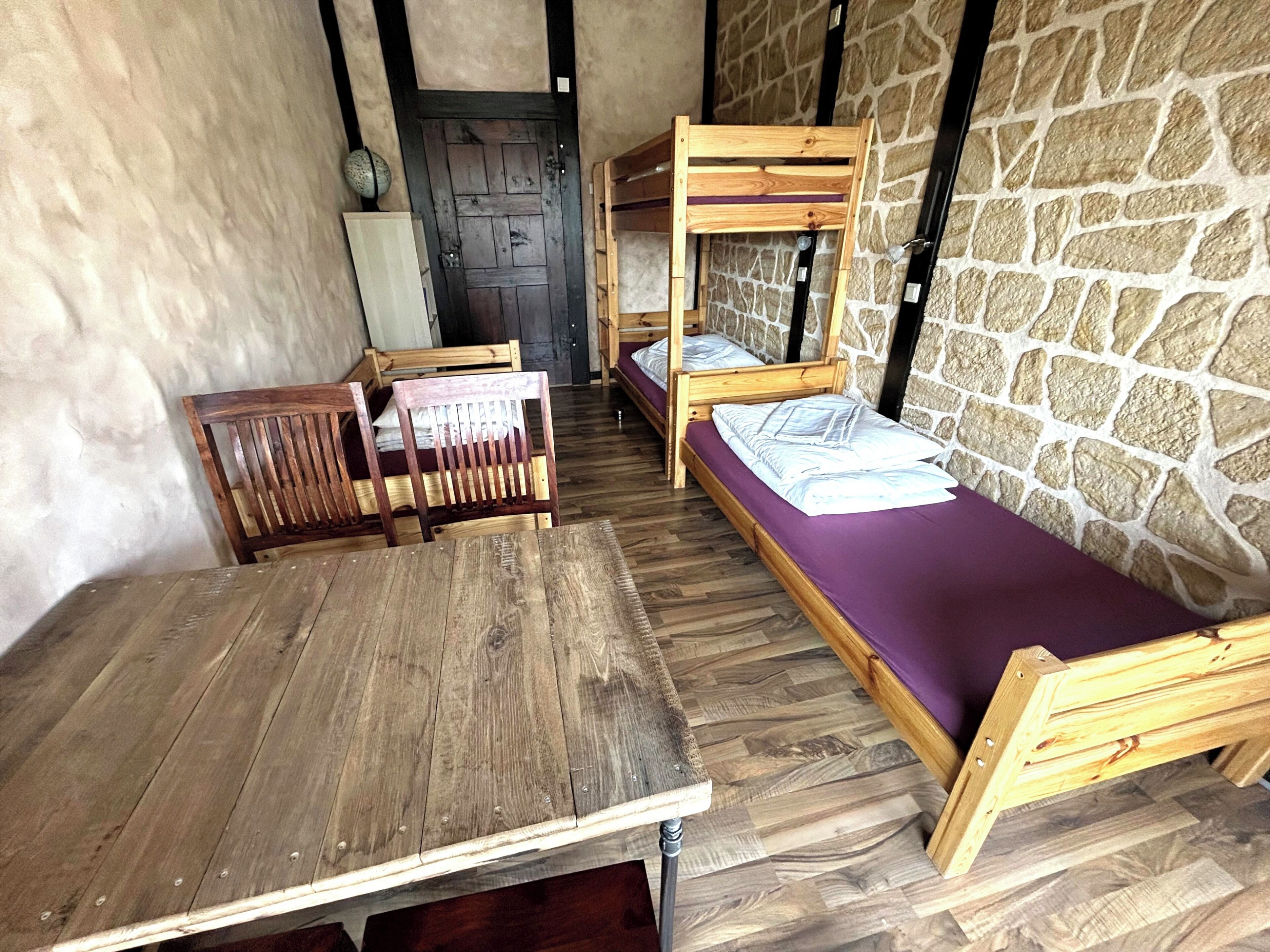 A rustic room with wooden furniture, including a table and bunk beds.