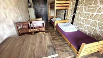 A rustic room with wooden furniture, including a table and bunk beds.