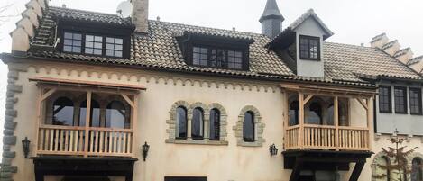 Un bâtiment traditionnel doté de nombreux balcons, de fenêtres en arc de cercle et d’un toit recouvert de tuiles.
